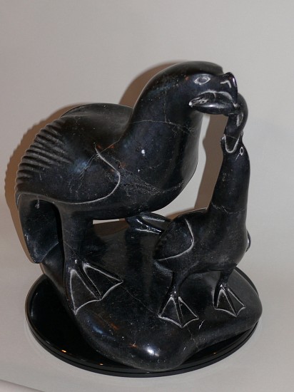 Thomassie Tookalook, Mother gull feeding fish to baby gull, c. 1970-1975
15 x 15 x 10 1/2 in.
Thomassie Tookalook is also known as Tamusi Qumalu Tukala. This carving combines the strength of Thomassie's birds, with maternal tenderness.  The mother gull is feeding a fish to its nestling.  Povungnituk artists carved naturalistic birds with great skill, and this is a stellar example.  In addition, the extensive negative space made this a very risky carving.
For a similar carving by Thomassie of a peregrine falcon, every inch a raptor, see
http://www.artnet.com/artists/thomassie-tookalook/peregrine-falcon-EktU3OxjiGbShI-XCxyhvA2
03704-1