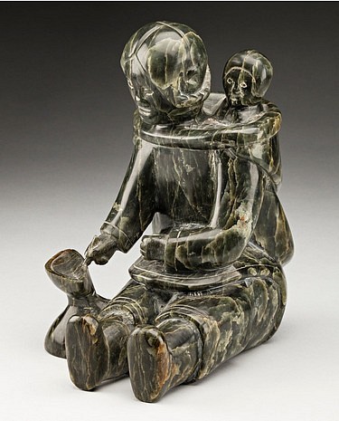 Mannumi Shaqu, Mother and child, tending a qulliq, 1953-1954
8 x 5 1/4 x 7 1/2 in.
This lovely work is a reprise by Mannumi of his famous Mother and Child of 1951 which was presented to Princess Elizabeth during her first royal visit to Canada in November of that year. That version was published in James Houston’s booklet Canadian Eskimo Art (Dept. of Northern Affairs and National Resources, 1954, p. 2). Interestingly, the work is carved from the attractive semi-translucent green stone used in Inukjuak. It had been discovered there in the early 1950s, so it’s possible that Houston had some on hand and offered it to Mannumi to carve. It is not known whether Houston specifically commissioned this subject from the artist, however. Although the subject is essentially the same, Mannumi made several changes to the composition, so the present work is not simply a copy but rather a reimagining of the original.

For years, the 1951 sculpture was attributed to Davidee Mannumi (1919-1979), also from Cape Dorset. In her research for the 2006 WAG exhibition Early Masters, Darlene Wight re-atttributed the work to Mannumi Shaqu, along with other sculptures that had been attributed to the other Mannumi. The section on Mannumi Shaqu in the Early Masters catalogue (pp. 162-167) illustrates several works of quite similar style.

References: See the section on the artist in Darlene Coward Wight, Early Masters: Inuit Sculpture 1949-1955, (Winnipeg: Winnipeg Art Gallery, 2006), pp. 162-167. See also Canadian Eskimo Art (Ottawa: Dept. of Northern Affairs and Natural Resources, 1954), p. 2; see Ken Mantel et al., Tuvaq: Inuit Art and the Modern World, (Bristol, UK: Sansom and Company Ltd., 2010), fig 42, p. 52; Maria von Finckenstein ed., Celebrating Inuit Art 1948-1970, (Hull, QC: Canadian Museum of Civilization [CMC], 1999), pp. 124-125. 
03554-1
