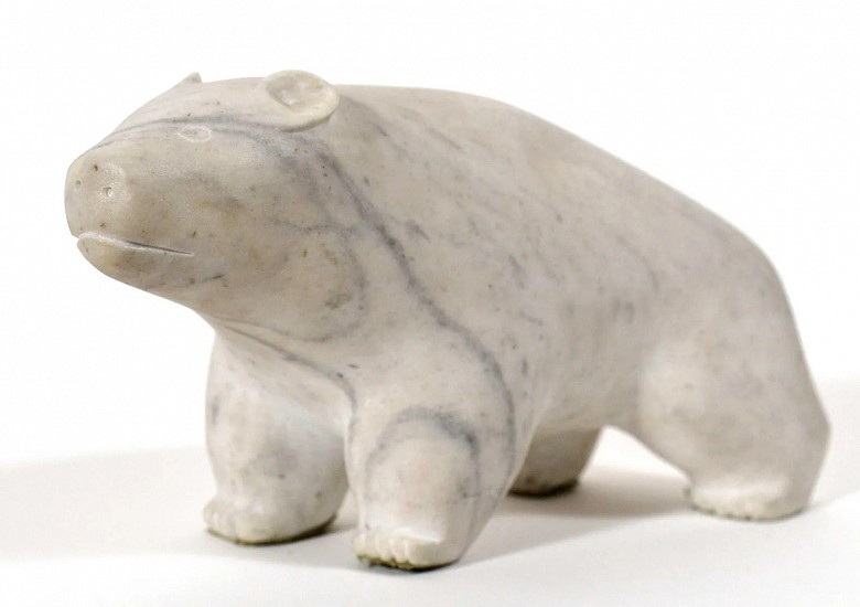 Abraham Etungat, Polar bear
Stone, 7 x 12 in. (17.8 x 30.5 cm)
Abraham Etungat was known primarily for his "birds of spring," tall, graceful birds with razor-thin wings carved in deep green serpentine.  This polar bear is their diametrical opposite.  It is carved from Andrew Gordon Bay marble, a hard, white quartz. Cape Dorset artists generally disliked it as a carving medium, because it was much more difficult to carve than serpentine.  When serpentine was not available, however, many swallowed their dislike and carved the marble.  Because of its density, the carvings -- like this bear -- tended to be bulky and rounded, with little detail.
03561-1