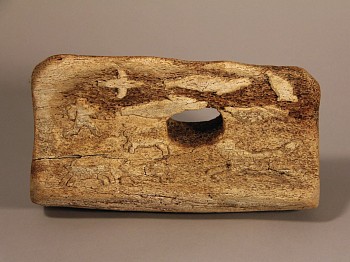 Work: Whalebone block with low relief carvings of seals, birds, dogs and man on a komatik